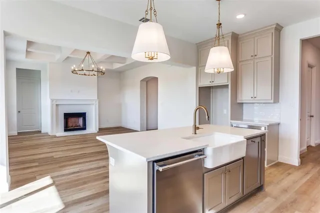 a kitchen with kitchen island a sink stainless steel appliances and wooden floor