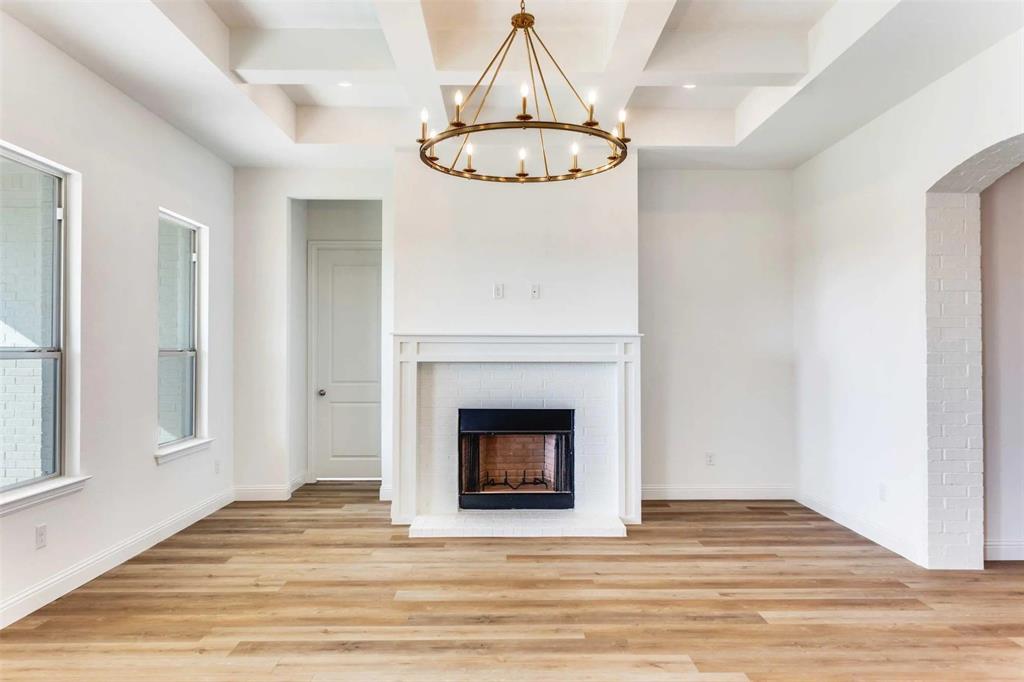 179 Galena Street Rhome, TX 76078 - Photo 9 of 17 a view of a livingroom with a fireplace and chandelier