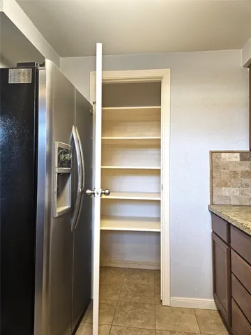 an empty room with wooden floor fireplace and windows