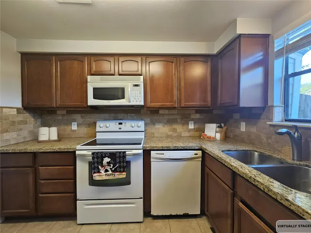 an empty room with windows fireplace and wooden floor