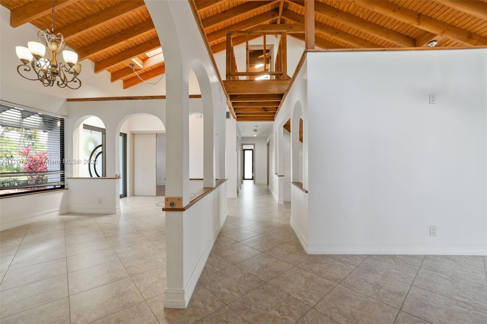 1501 Northwest 12th Terrace Boca Raton, FL 33486 - Photo 14 of 49 a view of a hallway with a dining room and chandelier