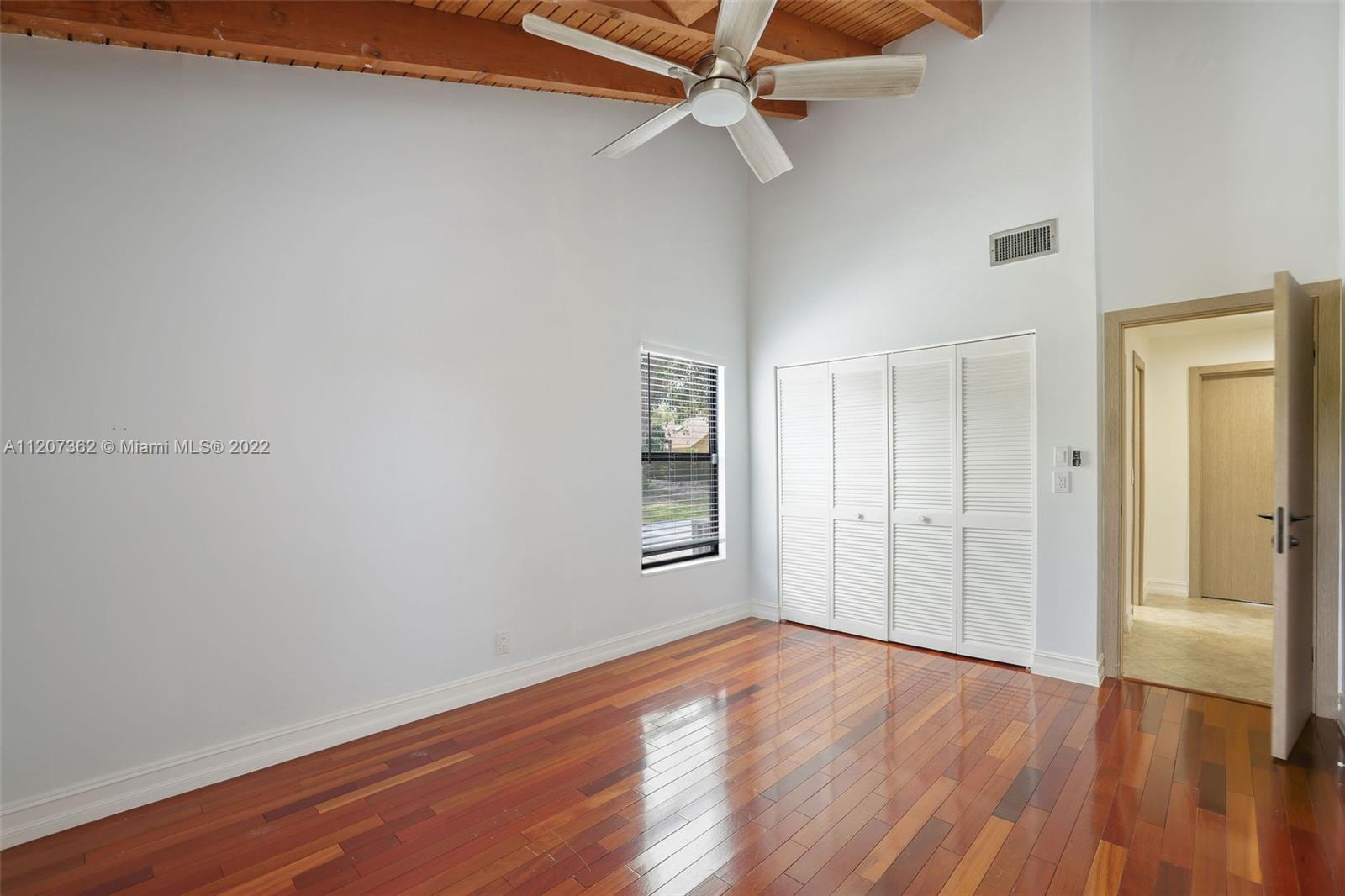 1501 Northwest 12th Terrace Boca Raton, FL 33486 - Photo 18 of 49 a view of empty room with wooden floor and fan