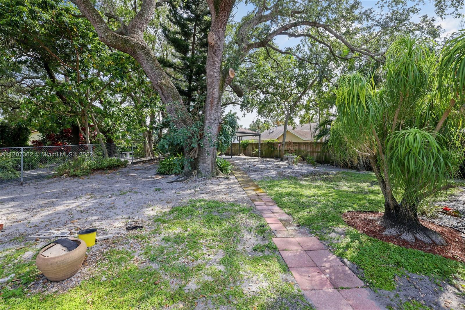 1501 Northwest 12th Terrace Boca Raton, FL 33486 - Photo 43 of 49 a view of a backyard with table and chairs plants and trees