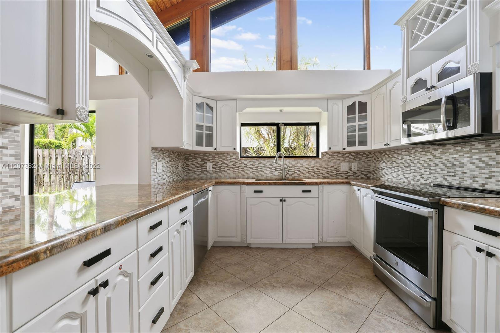 1501 Northwest 12th Terrace Boca Raton, FL 33486 - Photo 7 of 49 a kitchen with granite countertop a stove sink and microwave