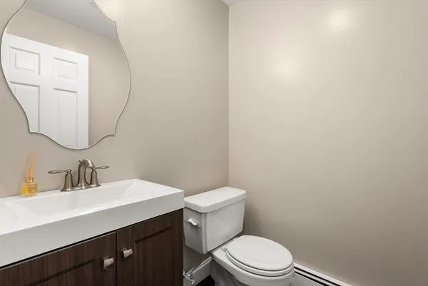 a bathroom with a toilet a sink and mirror