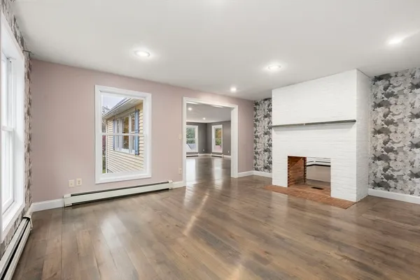 an empty room with wooden floor and fireplace