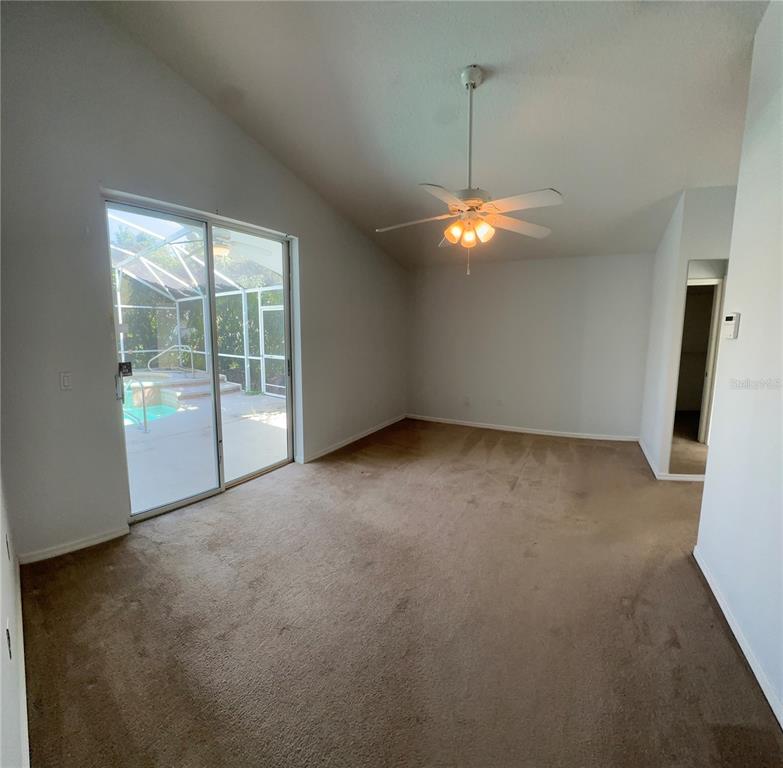 2823 Drifting Lilly Loop Kissimmee, FL 34747 - Photo 15 of 25 an empty room with chandelier fan and windows