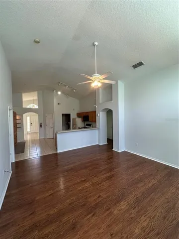 a view of an empty room with window and wooden floor