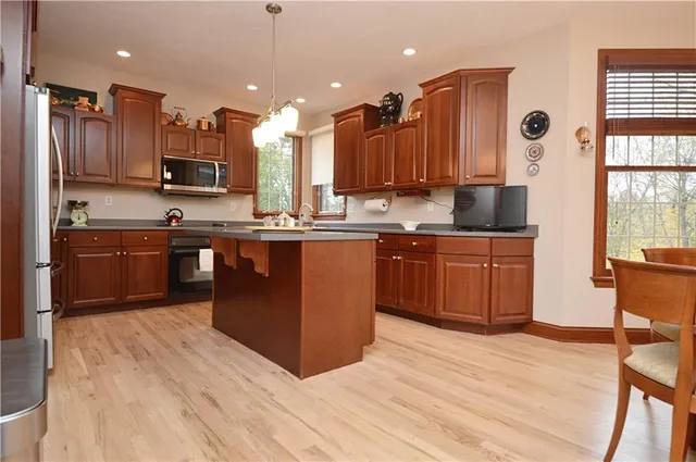 a kitchen with stainless steel appliances granite countertop a sink counter space cabinets and a large window