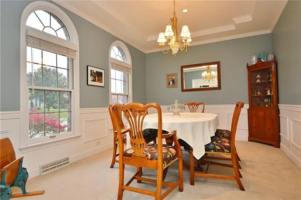 a view of a dining room with furniture a chandelier and a window