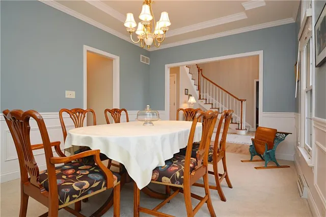 a view of a dining room with furniture a chandelier and wooden floor