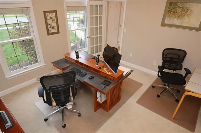 a view of a workspace with furniture and a window