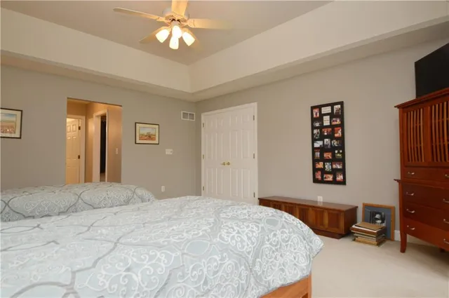 a bedroom with a bed a dresser and a chandelier