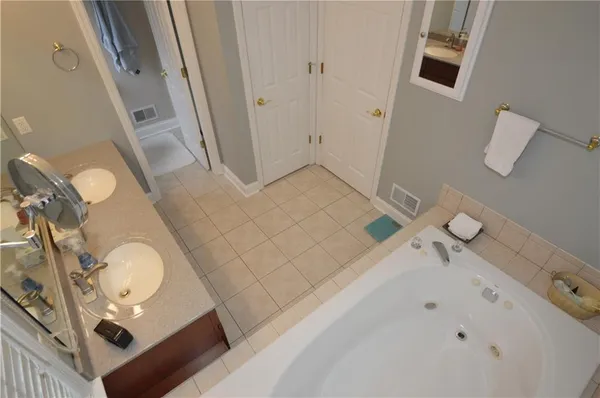 a bathroom with a tub sink and mirror