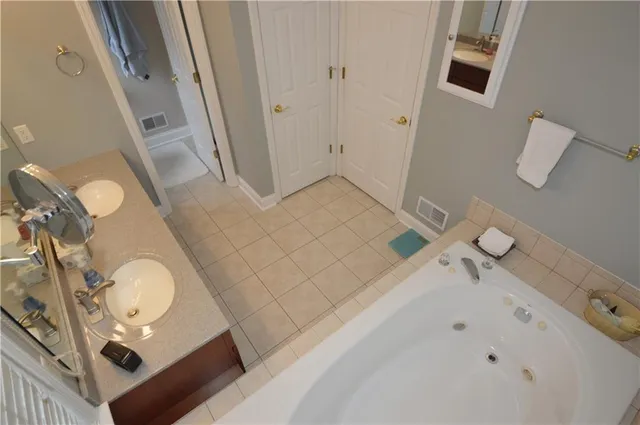 a bathroom with a tub sink and mirror