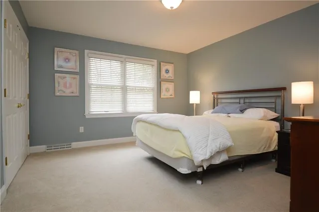 a bed sitting in a bedroom next to a window