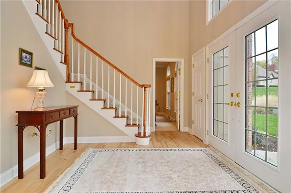 a view of front door with hallway and wooden floor