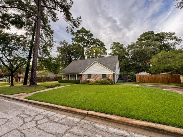 a view of a house with a yard and tree s