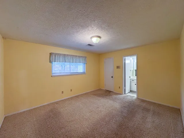 an empty room with a ceiling fan and windows