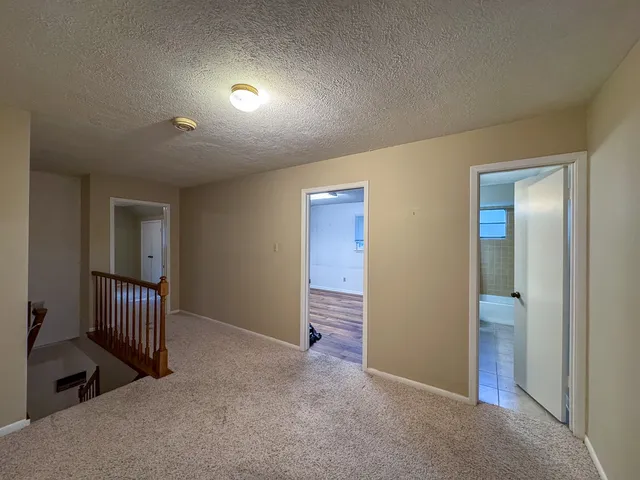 an empty room with staircase and a bathroom