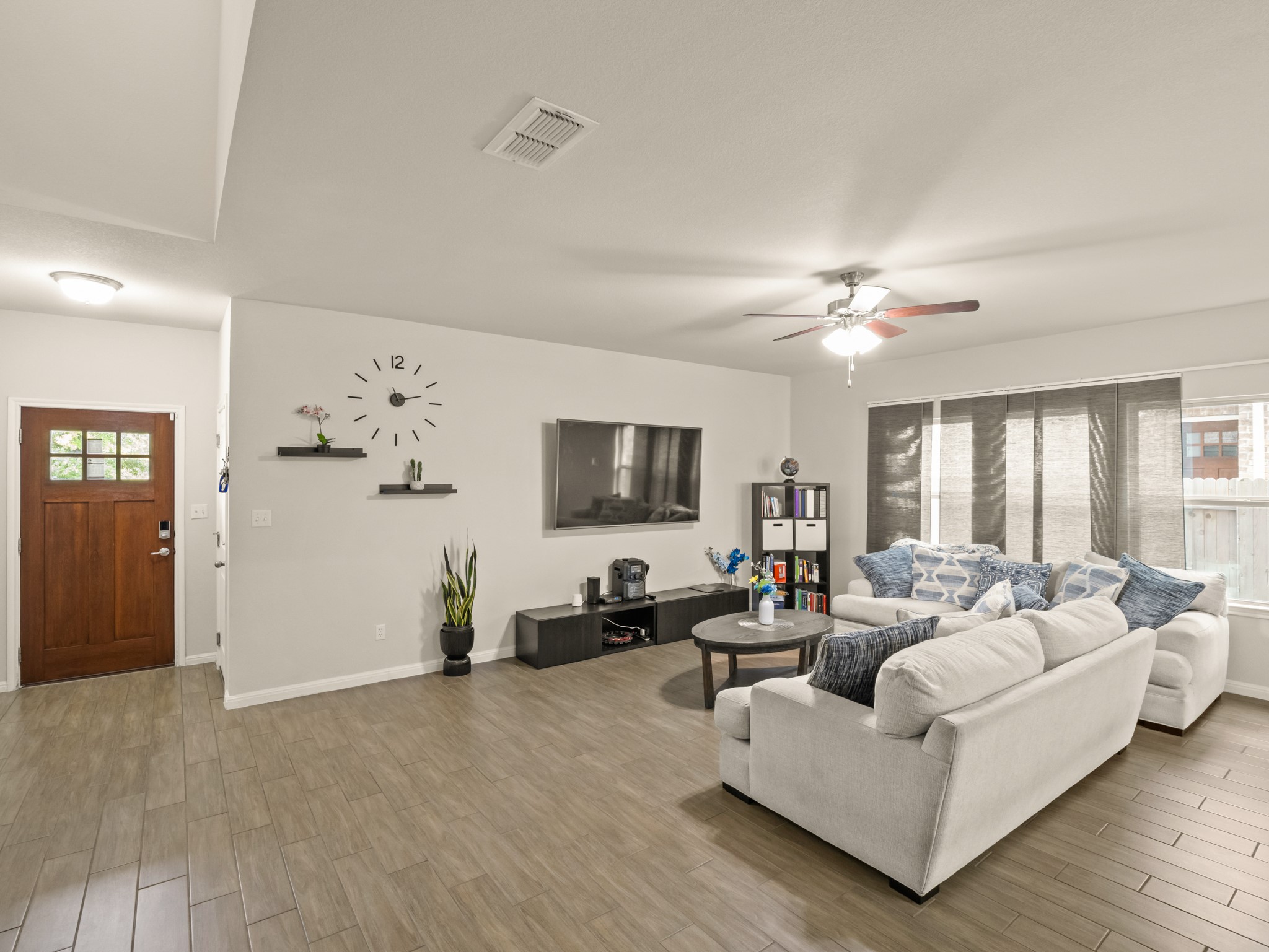 574 Nautical Loop Kyle, TX 78640 - Photo 5 of 23 The living room, a haven for relaxation, boasts stylish tile flooring and ample natural light from generous windows.