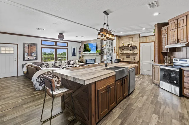 a kitchen with stainless steel appliances granite countertop a refrigerator a oven a sink and dishwasher