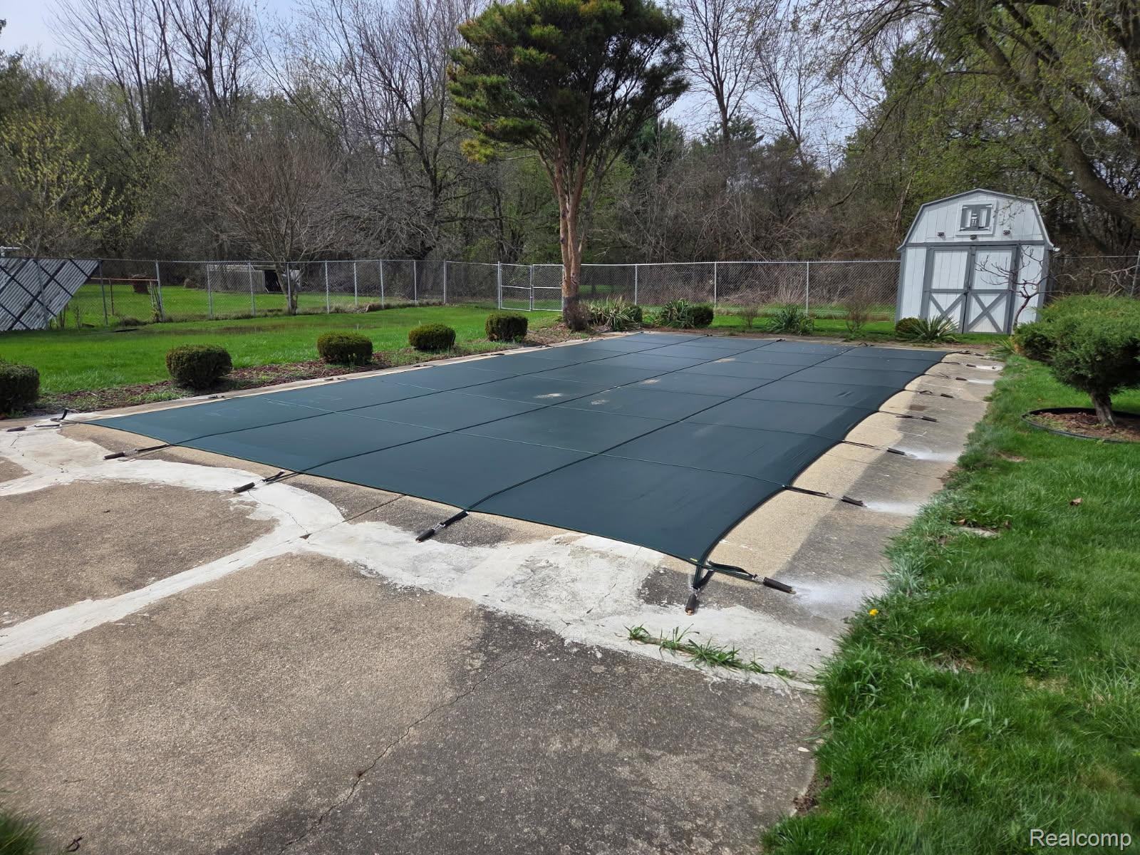 6443 Richfield Road Flint, MI 48506 - Photo 37 of 40 View of pool featuring a fenced backyard and a shed