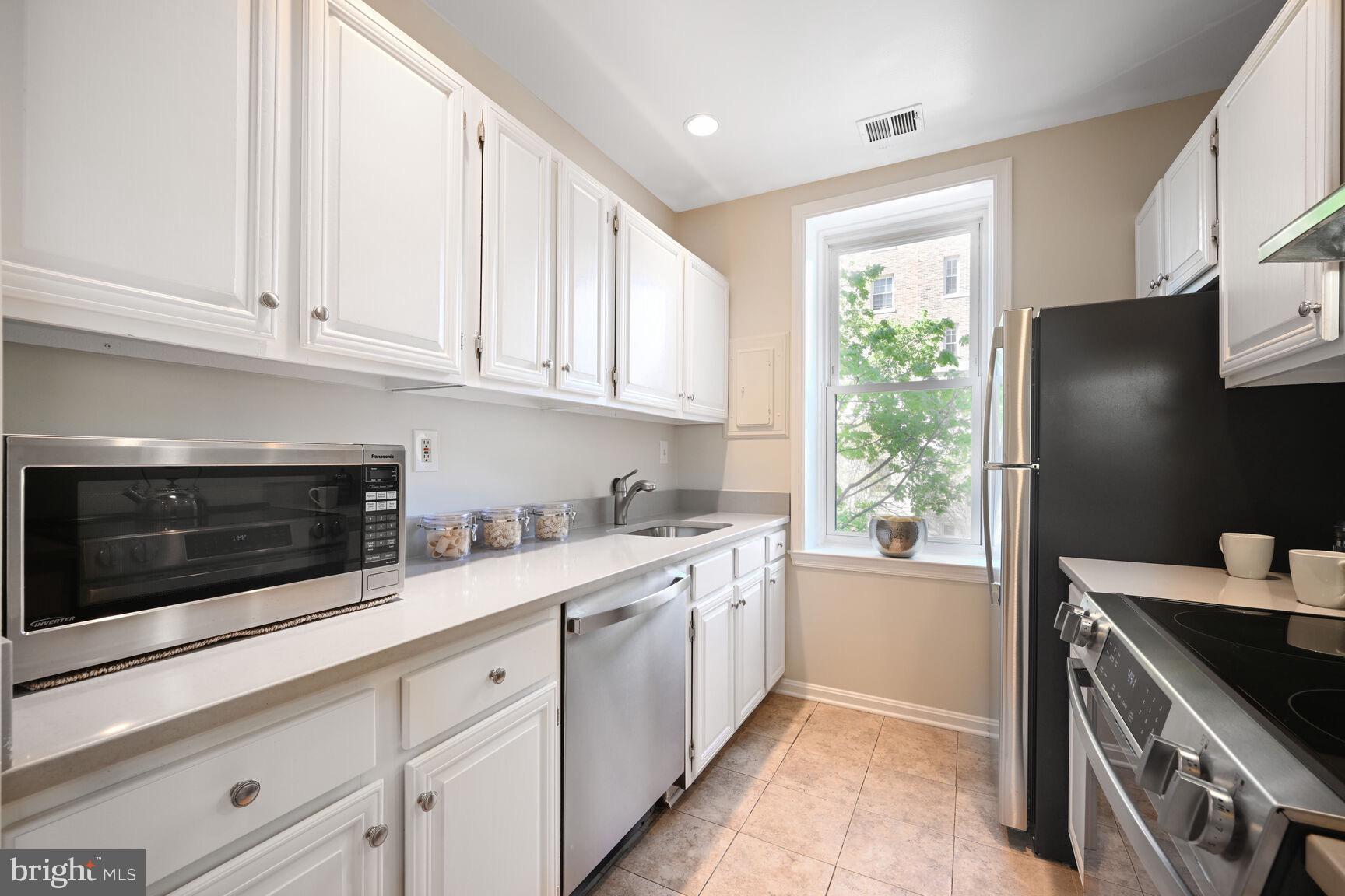 2001 16th Street Northwest, Unit 203 Washington, DC 20009 - Photo 6 of 15 a kitchen with stainless steel appliances white cabinets and a granite counter tops