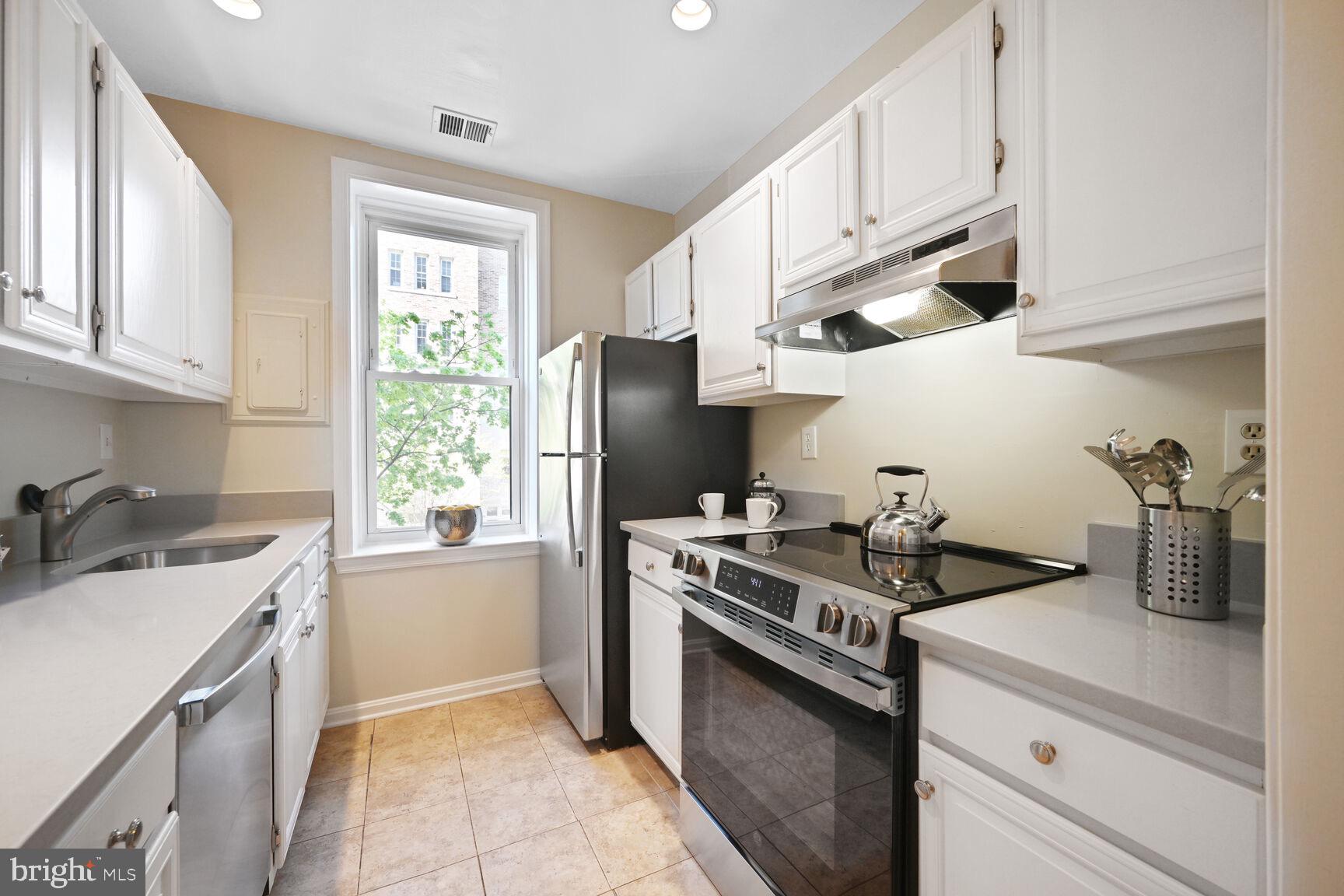 2001 16th Street Northwest, Unit 203 Washington, DC 20009 - Photo 7 of 15 a kitchen with stainless steel appliances granite countertop a sink stove and refrigerator