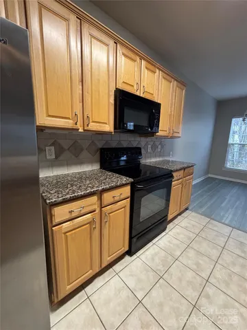 a kitchen with stainless steel appliances granite countertop a stove microwave and sink