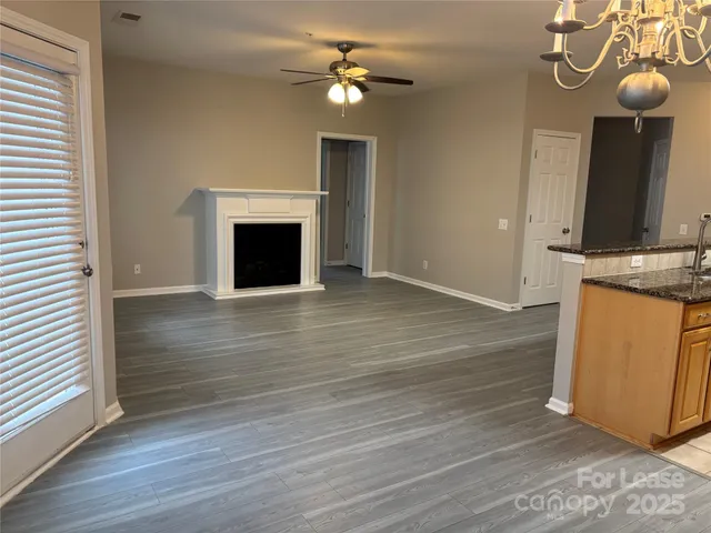 a view of a kitchen with a sink a fireplace and wooden floor