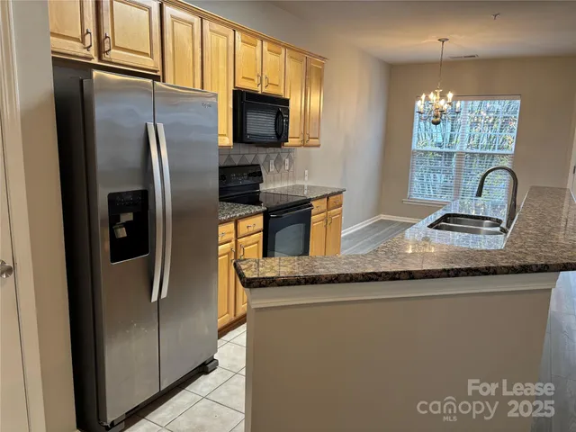 a kitchen with granite countertop stainless steel appliances a refrigerator and a counter space