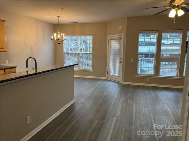 a view of a room with a large window and wooden floor