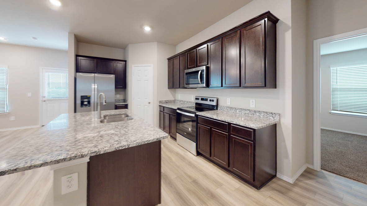 561 Hector Loop Georgetown, TX 78626 - Photo 7 of 30 a kitchen with stainless steel appliances granite countertop wooden cabinets a sink and dishwasher