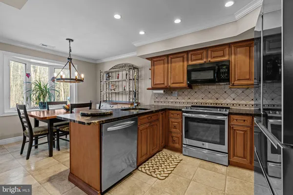 a kitchen with stainless steel appliances granite countertop a stove sink and microwave
