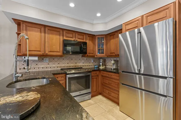a kitchen with granite countertop a refrigerator stove top oven and sink