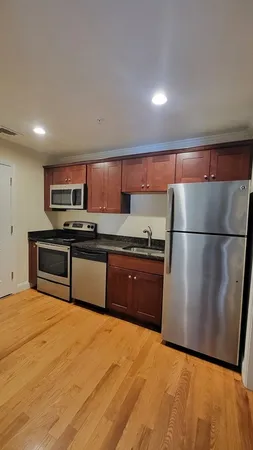 a kitchen with stainless steel appliances granite countertop a refrigerator a stove and a sink