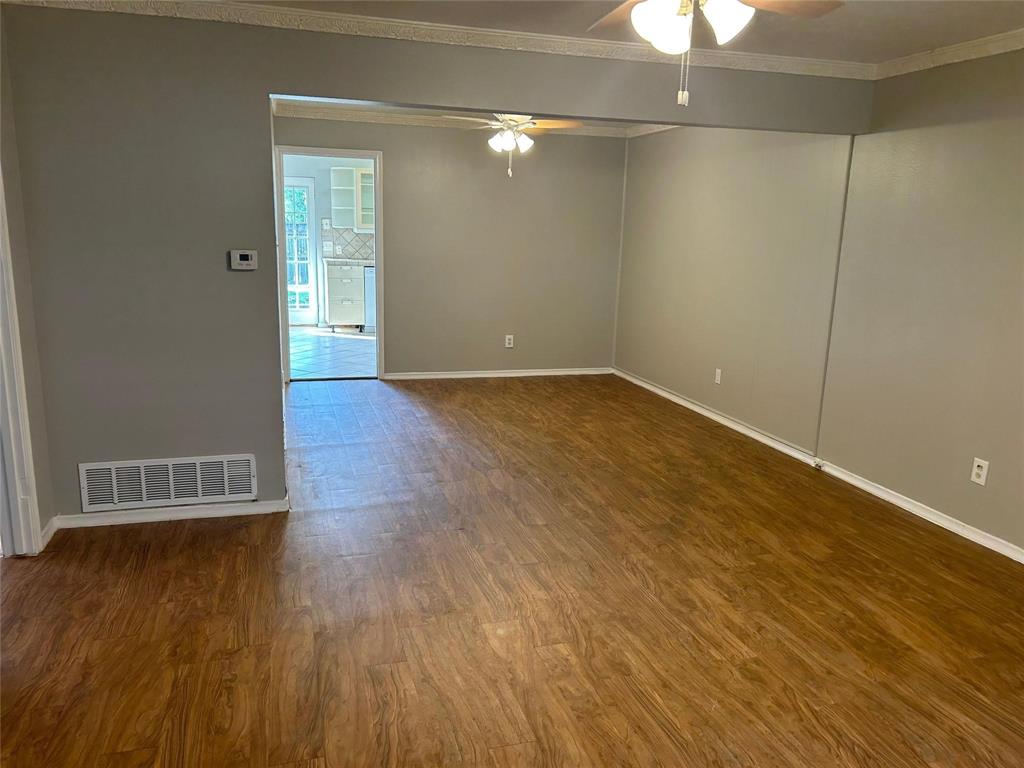 7458 Walling Lane Dallas, TX 75231 - Photo 2 of 10 an empty room with wooden floor and windows