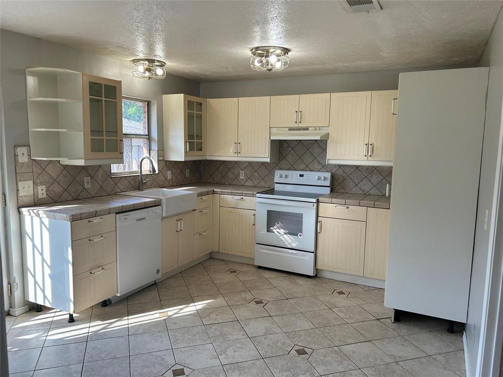 7458 Walling Lane Dallas, TX 75231 - Photo 3 of 10 a kitchen with a stove sink and cabinets