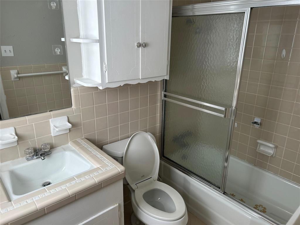 7458 Walling Lane Dallas, TX 75231 - Photo 5 of 10 a bathroom with a sink a toilet and shower