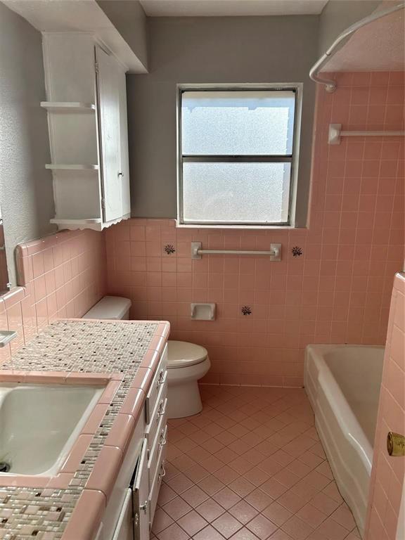 7458 Walling Lane Dallas, TX 75231 - Photo 7 of 10 a bathroom with a granite countertop sink a toilet and mirror