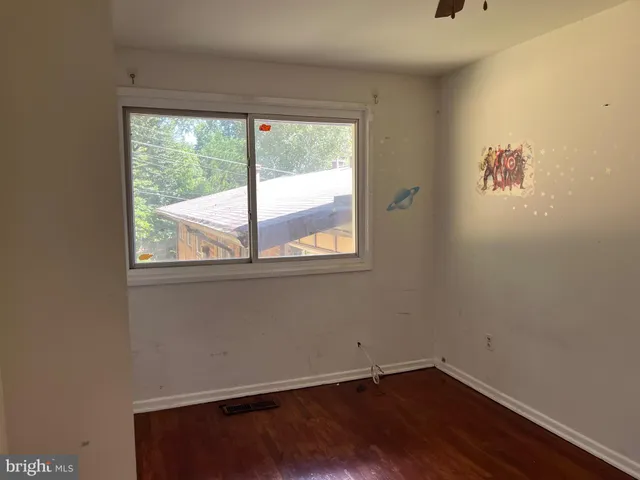a view of a small space with wooden floor and a window