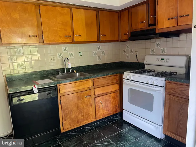 a kitchen with granite countertop cabinets stainless steel appliances and a sink