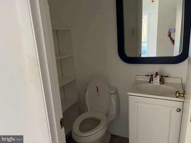 a bathroom with a toilet sink and mirror
