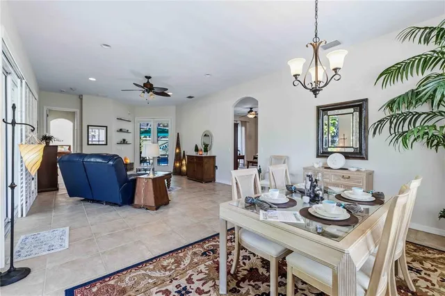 a dining room with chandelier furniture and a large window
