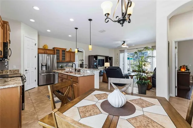 a kitchen with granite countertop a stove a sink and a dining table