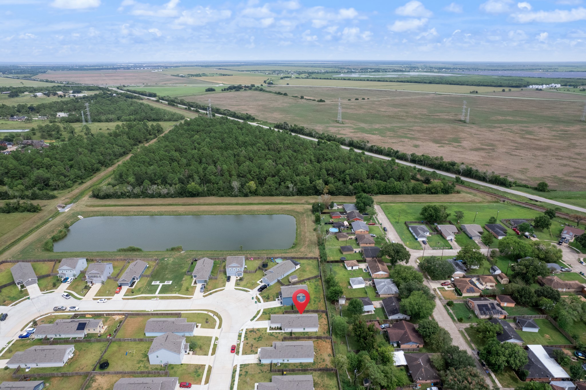 252 Houston Street Angleton, TX 77515 - Photo 46 of 49 This elevated perspective places the home in context with nearby residential streets, open land, wooded areas, and the community pond.