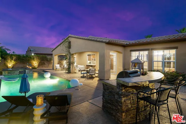a patio with table and chairs and potted plants