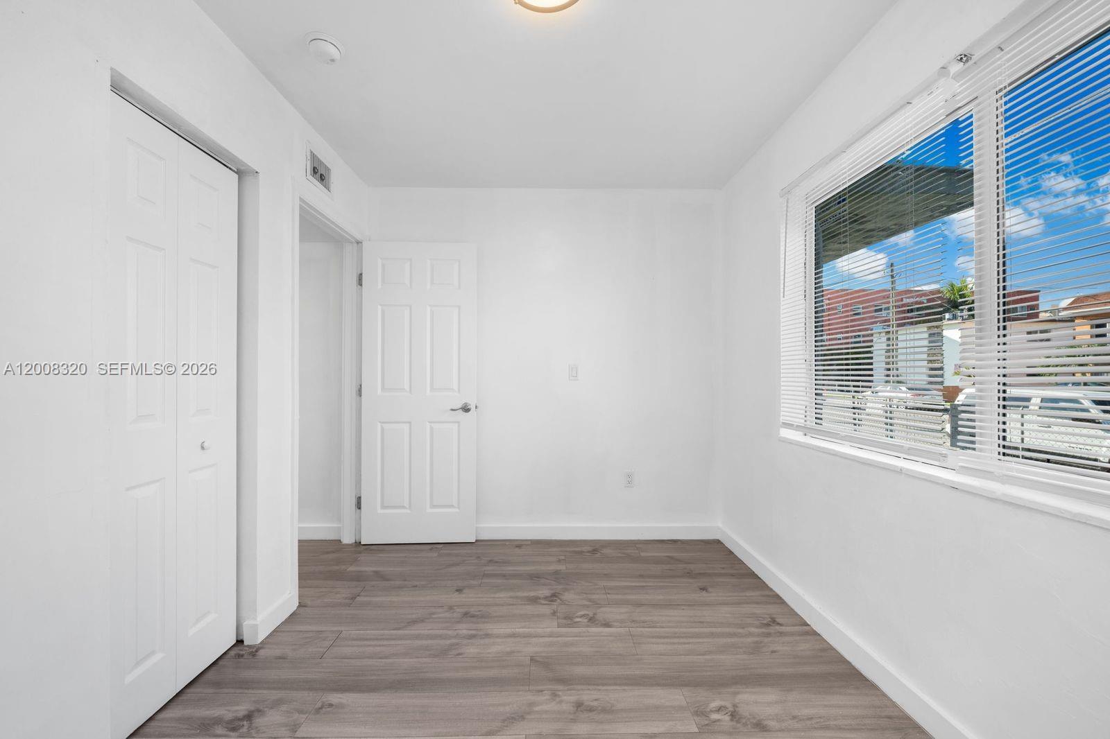 842 Southwest 3rd Street Miami, FL 33130 - Photo 13 of 13 a view of an empty room with wooden floor and a window