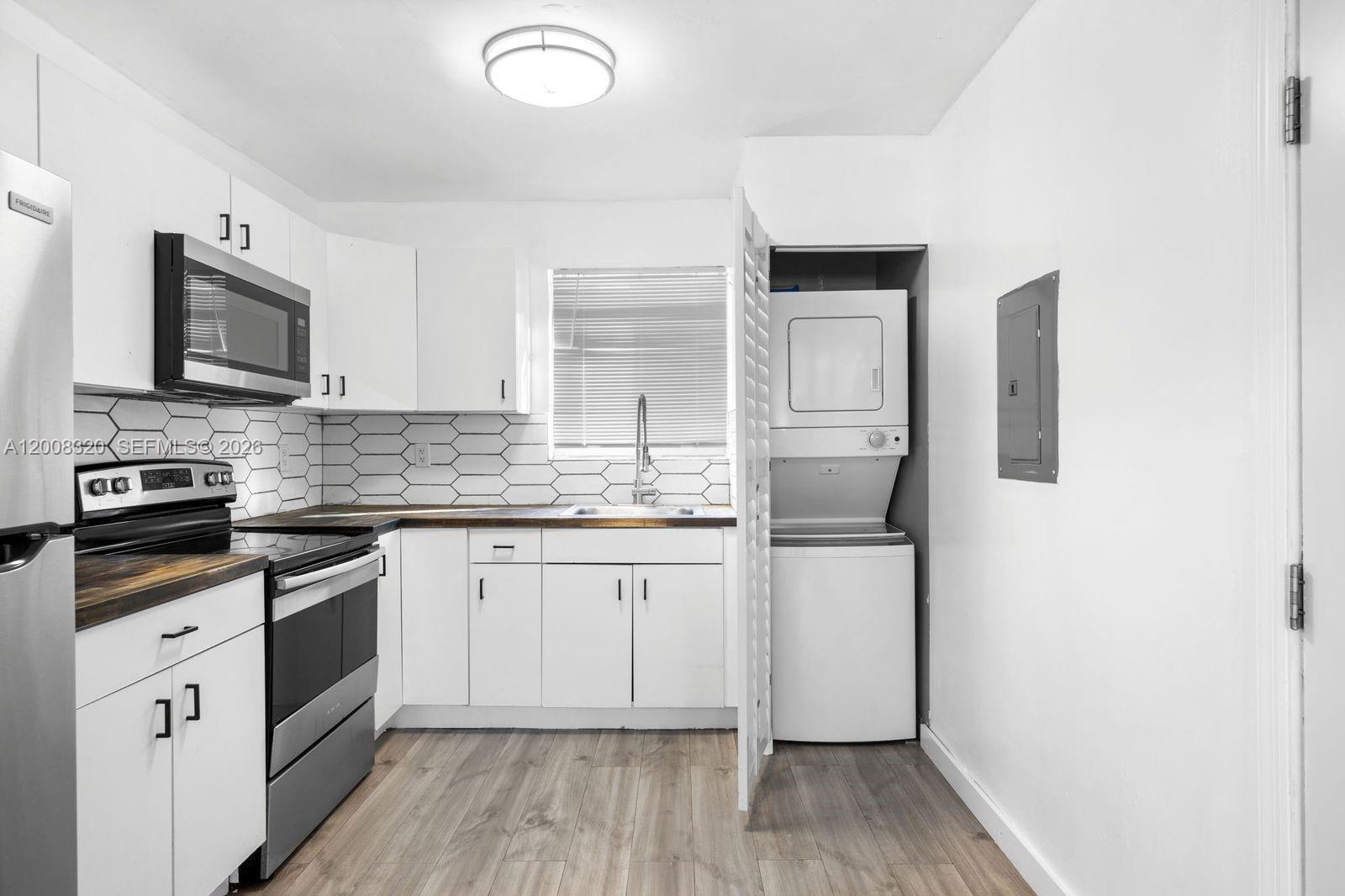 842 Southwest 3rd Street Miami, FL 33130 - Photo 5 of 13 a kitchen with stainless steel appliances a refrigerator sink and cabinets